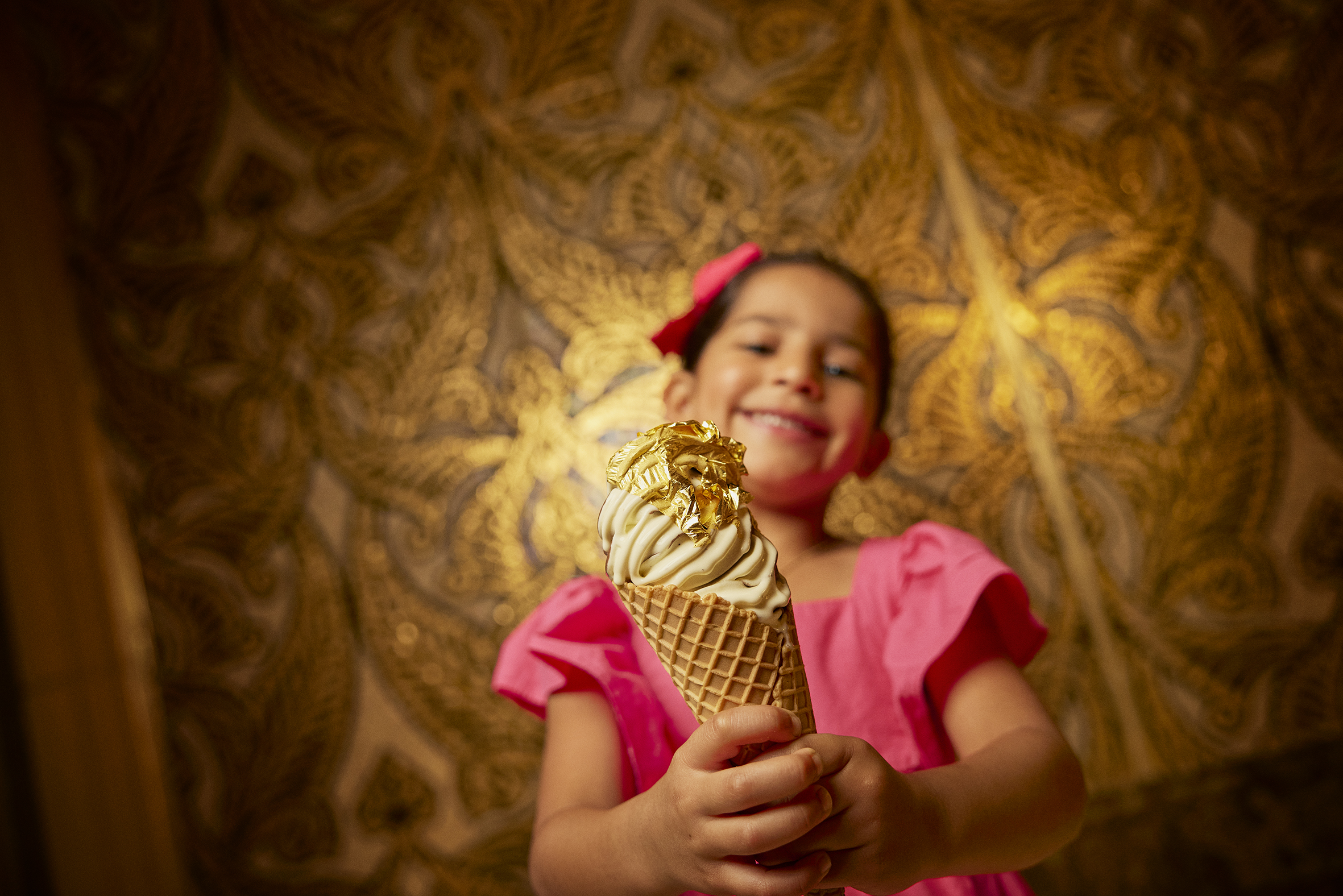 A small girl is holding an ice cream